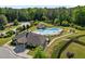Aerial view of the community pool area with a clubhouse, surrounded by lush landscaping and lounge chairs at 212 Crisp Rd, Durham, NC 27713