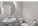 Cozy powder room with a pedestal sink, toilet, and a decorative round mirror at 212 Crisp Rd, Durham, NC 27713