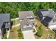 Aerial view of a two-story home with a well-manicured lawn, adjacent to homes with solar panels at 214 Dogwood Blossoms Dr, Durham, NC 27703