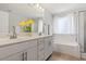 Bright bathroom with double sinks, white cabinets, and separate bathtub at 214 Dogwood Blossoms Dr, Durham, NC 27703