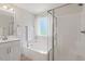 Bright bathroom featuring a soaking tub, glass shower, and a white vanity with sleek fixtures at 214 Dogwood Blossoms Dr, Durham, NC 27703