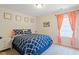 Cozy bedroom with neutral walls, a comfortable bed, and windows dressed with coral curtains at 214 Dogwood Blossoms Dr, Durham, NC 27703