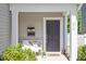 Inviting front porch with seating, decorative plants and flowers and a welcoming front door at 214 Dogwood Blossoms Dr, Durham, NC 27703