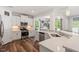 Open-concept kitchen featuring stainless appliances, a quartz countertop, and warm, wood-look flooring at 214 Dogwood Blossoms Dr, Durham, NC 27703
