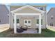 Covered outdoor patio with seating, ceiling fan, and access to the backyard at 214 Dogwood Blossoms Dr, Durham, NC 27703
