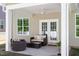 Cozy covered patio seating area with white columns, ceiling fan, and backyard view at 214 Dogwood Blossoms Dr, Durham, NC 27703