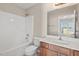 Well-lit bathroom featuring a tub, toilet, and vanity with a large mirror at 235 Michigan Ave, Cary, NC 27519