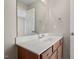 A bathroom features a wood vanity with drawers and a white countertop and backsplash at 235 Michigan Ave, Cary, NC 27519