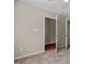Bedroom with plush carpeting and open doors, offering a glimpse of hardwood flooring beyond at 235 Michigan Ave, Cary, NC 27519