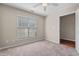 Bright bedroom with a ceiling fan, neutral carpet, and a large window for natural light at 235 Michigan Ave, Cary, NC 27519