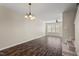 Open-concept dining area featuring stylish chandelier and dark wood-look floors at 235 Michigan Ave, Cary, NC 27519