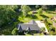 Aerial view of a brick home with mature trees, a garden and a driveway at 2457 Millbrook Dr, Haw River, NC 27258