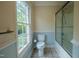 Bright bathroom with tiled floors, glass shower, and a large window at 2457 Millbrook Dr, Haw River, NC 27258