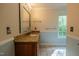 Well-lit bathroom featuring a granite countertop and decorative mirror at 2457 Millbrook Dr, Haw River, NC 27258