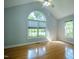 Bedroom with large arched window, hardwood floors, vaulted ceiling, and natural light at 2457 Millbrook Dr, Haw River, NC 27258