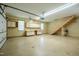 Bright garage with staircase, built-in cabinets, and work area, providing functionality and storage solutions at 2457 Millbrook Dr, Haw River, NC 27258