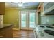 Kitchen area showcasing a back door exit and stove at 2457 Millbrook Dr, Haw River, NC 27258