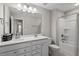 Bright bathroom features double sinks, white vanity, and a shower-tub combination at 2650 Turner Pines Dr, New Hill, NC 27562