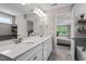 Bright bathroom featuring a dual sink vanity, quartz countertops, tile flooring, and a view into an adjacent bedroom at 2650 Turner Pines Dr, New Hill, NC 27562
