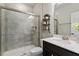 Bathroom featuring a tiled walk-in shower with glass door, dark vanity, and ample counter space at 2650 Turner Pines Dr, New Hill, NC 27562