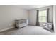 Bedroom with carpeted floors, a crib, and a gray chair with a small window view at 2650 Turner Pines Dr, New Hill, NC 27562