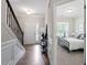 Inviting entryway features hardwood floors, staircase with iron railings, and a view into the bedroom at 2650 Turner Pines Dr, New Hill, NC 27562