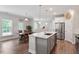 Open kitchen with center island and stainless appliances flows into the living and dining areas at 2650 Turner Pines Dr, New Hill, NC 27562