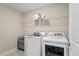 Bright laundry room featuring a front-load washer and dryer set, wire shelving, and gray tile flooring at 2650 Turner Pines Dr, New Hill, NC 27562