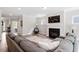 Open-concept living room with fireplace, large sofa, and seamless flow into dining and kitchen areas at 2650 Turner Pines Dr, New Hill, NC 27562