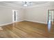 This bedroom features hardwood flooring, tray ceilings, a ceiling fan, and natural lighting at 280 Dreamcatcher Trl, Youngsville, NC 27596