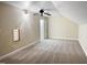 This attic bedroom features tan carpet, a ceiling fan, and a side window at 280 Dreamcatcher Trl, Youngsville, NC 27596