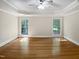 This bedroom features hardwood flooring, tray ceilings and two windows with natural lighting at 280 Dreamcatcher Trl, Youngsville, NC 27596