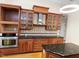 Close up of the kitchen features stainless oven and range hood with glass front cabinets at 280 Dreamcatcher Trl, Youngsville, NC 27596