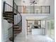 Open-concept living room with spiral staircase, white marble floors, and kitchen access at 280 Dreamcatcher Trl, Youngsville, NC 27596