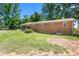 Spacious backyard with grassy lawn and view of the brick home's exterior at 2917 Trail Six, Burlington, NC 27215