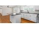 Bright kitchen with white cabinets, black countertops, hardwood floors and a kitchen island at 2917 Trail Six, Burlington, NC 27215