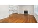 Open-concept living area flowing into a bright white kitchen, featuring hardwood floors and a cozy fireplace at 2917 Trail Six, Burlington, NC 27215