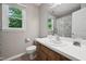 Well-lit bathroom with a vanity, toilet, and window providing natural light and ventilation at 300 Hutchins Dr, Garner, NC 27529