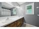 Bathroom with dual sinks, large mirror, natural light, and gray walls at 300 Hutchins Dr, Garner, NC 27529