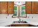 Kitchen with corner sink, double windows and warm wood cabinets at 300 Hutchins Dr, Garner, NC 27529