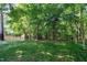 The backyard features a well maintained lawn, mature trees, and a wooden fence at 300 Silvercliff Trl, Cary, NC 27513