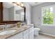 Bathroom featuring a double granite vanity with a large decorative framed mirror at 300 Silvercliff Trl, Cary, NC 27513
