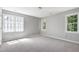 Bright and airy bedroom with multiple windows, carpeting, and neutral walls, creating a comfortable atmosphere at 300 Silvercliff Trl, Cary, NC 27513