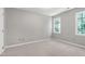 Carpeted bedroom with neutral walls and bright windows, offering a blank canvas for personalization at 300 Silvercliff Trl, Cary, NC 27513