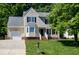 Charming two-story home with a well-manicured lawn, attached garage, and inviting front porch at 300 Silvercliff Trl, Cary, NC 27513