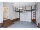 View of the attached garage featuring painted walls, brick trim, and overhead storage racks at 300 Silvercliff Trl, Cary, NC 27513