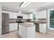 The kitchen features white cabinets, stainless steel appliances, granite counters, and an island at 300 Silvercliff Trl, Cary, NC 27513