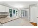 Bright kitchen area with a granite countertop, large windows, and view into an adjacent room at 300 Silvercliff Trl, Cary, NC 27513