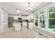 Bright eat-in kitchen features white cabinets, stainless steel appliances, and a large window overlooking the backyard at 300 Silvercliff Trl, Cary, NC 27513