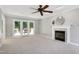 Spacious living room featuring a fireplace, ceiling fan, and glass doors leading to the deck at 300 Silvercliff Trl, Cary, NC 27513